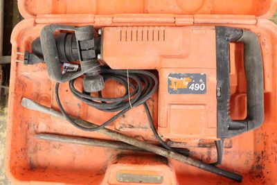 an orange tool box with a hammer and other tools in it