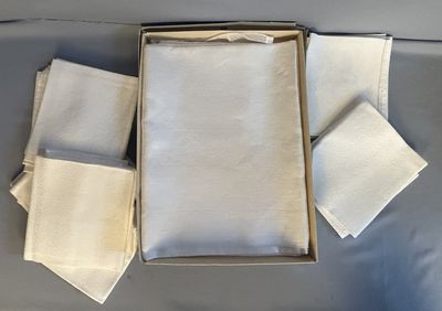 quatre serviettes dans une boîte posée sur une table