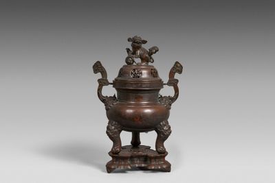 un ancien brûle-parfum en bronze surmonté d'un oiseau