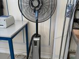 a fan that is sitting on the floor next to a table