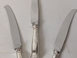 three knives that are sitting on top of a table