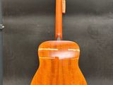 an orange guitar sitting on top of a wooden stand next to a black suitcase