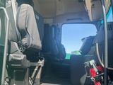 a man sitting in the back seat of a green truck