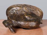 a small bronze sculpture of a snail on a table