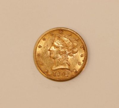 a close up of a gold coin on a white surface