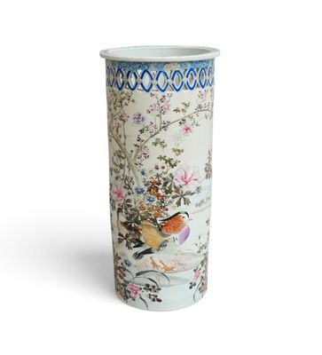 a tall vase with a bird and flowers on it