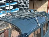 a small blue car parked in front of a building with graffiti on the wall
