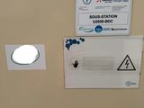 a toilet in a bathroom with a sign on the wall