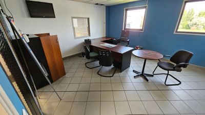 une pièce équipée d'un bureau, de chaises et d'une télévision