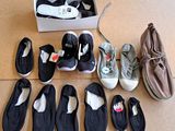 Plusieurs paires de chaussures sont disposées par terre à côté d'une boîte à chaussures.