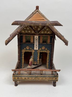 a small wooden house with a roof made of wood