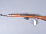 a rifle with a wooden barrel on a gray surface