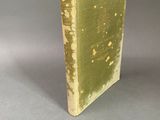 an old book sitting on top of a table covered in green paint