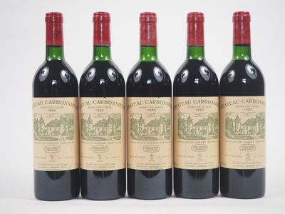 trois bouteilles de vin rouge sont alignées sur une surface blanche