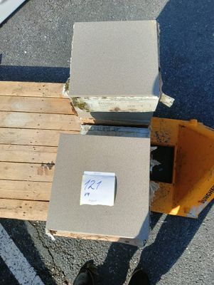 une palette sur laquelle sont posées des cartons, avec une personne debout à côté