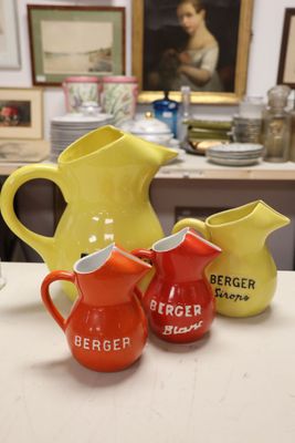 three pitchers sitting on a table next to each other