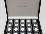 a black box filled with silver coins sitting on top of a white table
