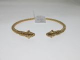 gros plan d'un bracelet en or sur une surface blanche