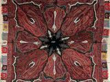 une photo d'un tapis rouge, noir et blanc orné d'un motif floral