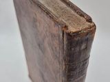 an old book sitting on top of a white table next to a white wall