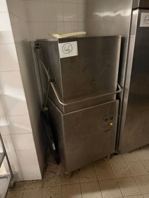 a silver refrigerator in a kitchen next to a white tiled wall