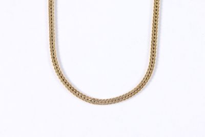 gros plan d'un collier en chaîne en or sur fond blanc