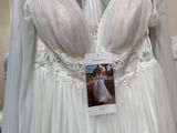 a wedding dress hanging on a rack in a store