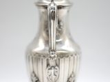 an antique silver coffee pot with a handle on a stand
