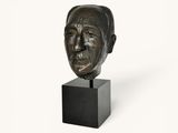 sculpture of a man ' s head on a black stand