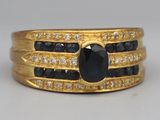 a close up of a ring with a black stone surrounded by white diamonds