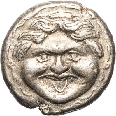 a silver coin with a smiling face on it