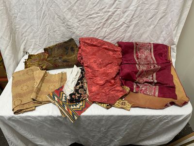 une table blanche recouverte de nombreuses nappes de styles variés