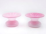 pair of pink glass candlesticks on a white background