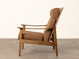 the chair is made of wood and has a brown upholstered seat