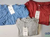 trois t-shirts avec leurs étiquettes de prix, posés sur une table