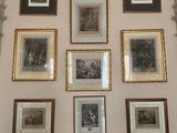 many framed pictures on the wall of this room