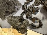 many different pieces of jewelry on display on a table