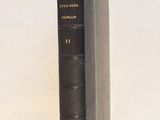 un vieux livre noir posé sur une table blanche