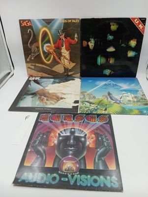 un lot de quatre disques vinyles posés sur une table blanche