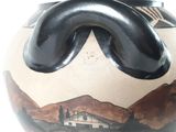 a vase with a picture of a house and mountains on it