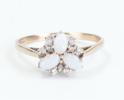 a close up of a white oplite and diamond ring on a white background