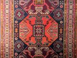 a red and blue rug with an ornate design on it