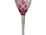 purple and white wine glass sitting on top of a white table