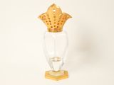 a glass vase with a gold crown on top of it