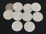 un grand nombre de pièces de monnaie qui se trouvent sur une surface noire