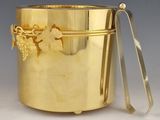 a gold metal container with a handle and a spoon