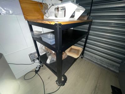 une charrette noire sur laquelle sont posés quelques objets