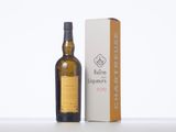the bottle of whisky is next to the box on the table