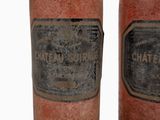 pair of old wine bottles with labels on them sitting next to each other
