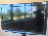 a flat screen tv sitting on a stand in front of a window